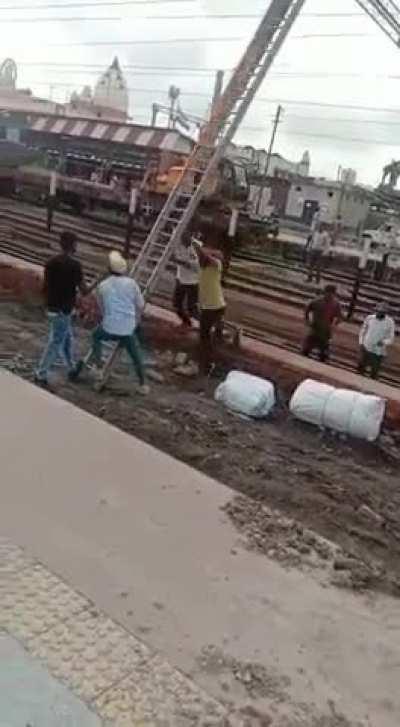 Two Indian workers were electrocuted while installing a pole on a railway