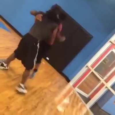 Two dudes brawling in the gym basketball court