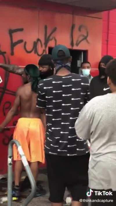 Membro do Black lives matter impedindo pessoas de roubar estabelecimento durante os protestos de Minneapolis.