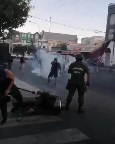 Chilean protestor performs a double leg takedown on a charging police officer