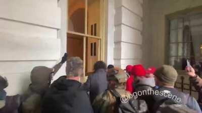 Pro-Trump rioters breaking the Capitol building windows...