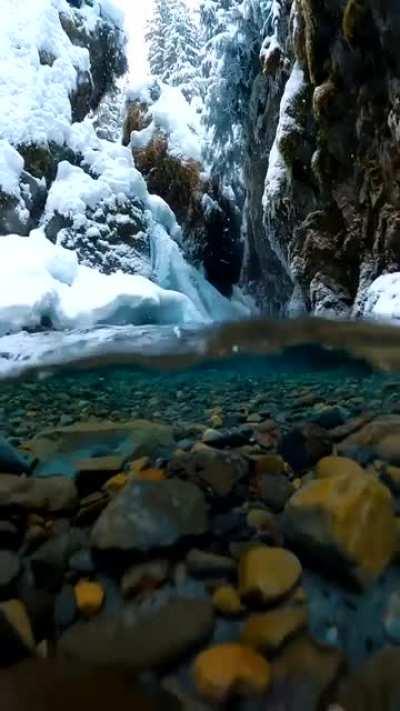 🔥 Snow falling on crystal clear Alaskan glacial melt water captured by photographer John Derting.