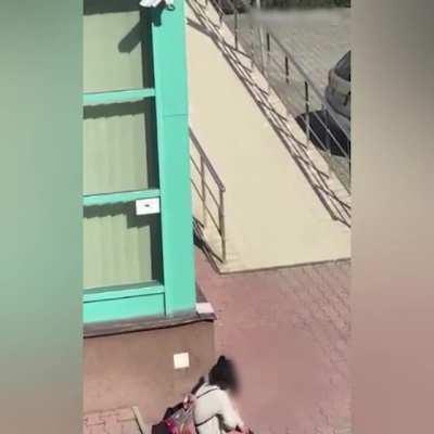 when you gotta go, you gotta go. women rubs a really dry one outside a building.