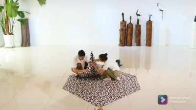 This couple folding a life size paper leopard