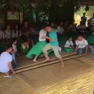 Young dancers in the Philippines performing a traditional bamboo dance known as Tinikling