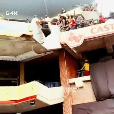 A football fan saving another one on a game in south africa.