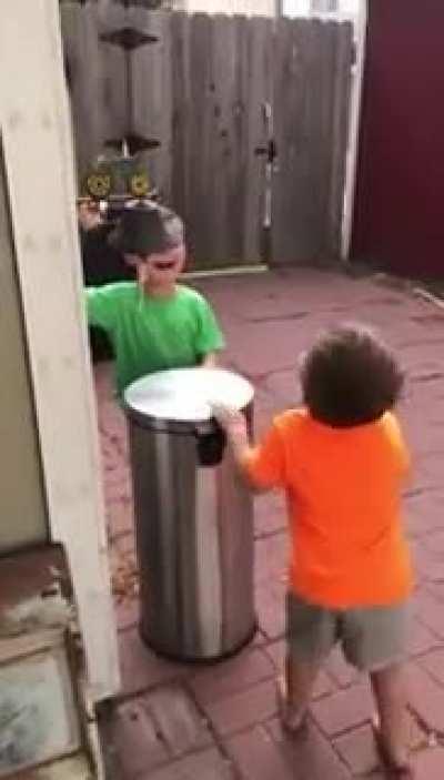 Kids Jokingly Hit Each Other With Trash Can's Lid by Stepping on Its Pedal