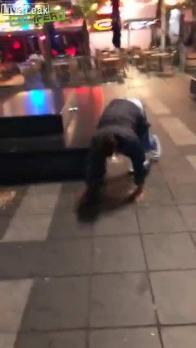 Idiot tries to kick pigeon but instead slips and fall in puke.