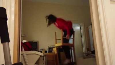 Standing on two chairs on top eachother to change the lightbulb