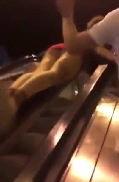 Trying to bodysurf an escalator's handrail