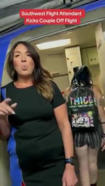 A flight attendant stops a couple from getting on the plane.