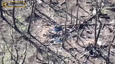 Ukrainian soldier clearing a foxhole with what seems to be a satchel charge 