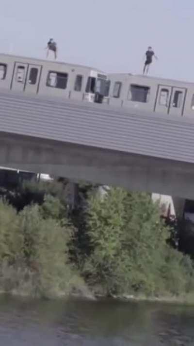 Jumping off a moving train into the river.