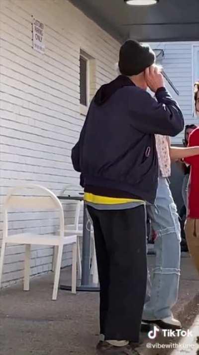 A miserable man stands outside of an icecream place ruining everyone’s mood