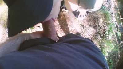Gagging on his dick outdoors next to a walking trail