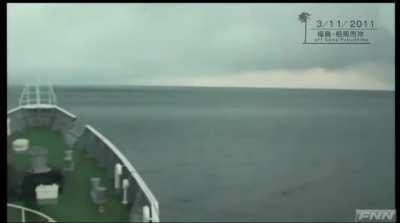 Japanese coast guard patrol boat encountering a giant tsunami off the coast of Fukushima prefecture after a massive earthquake on 11th March 2011