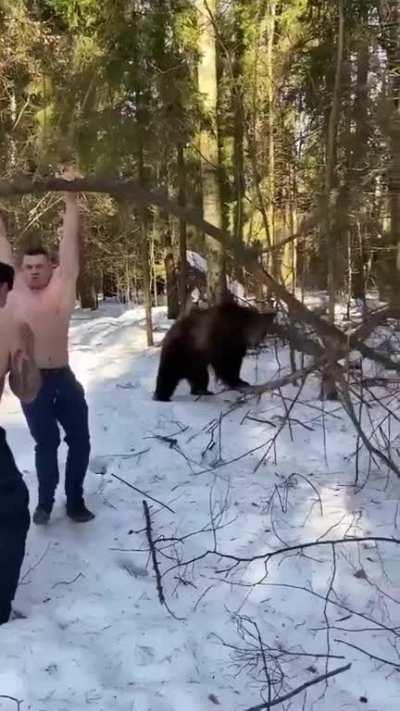 Two men working out with a bear