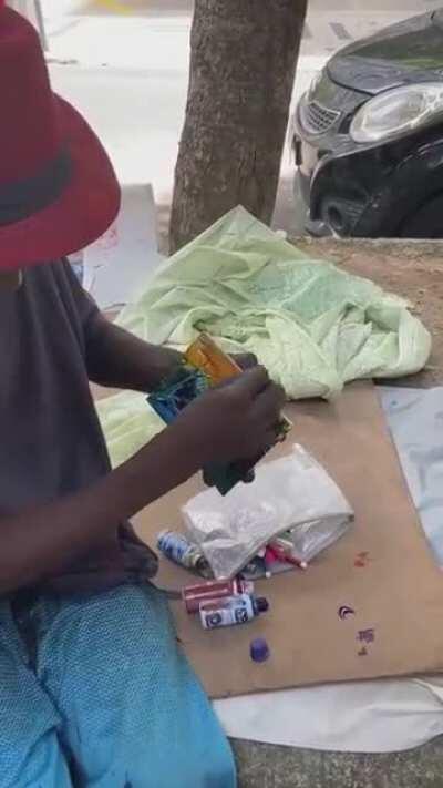 A talented poor man drawing a beautiful scenery