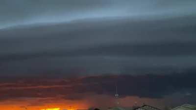 Enormous shelf cloud and storm in front of a sunset