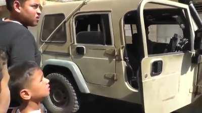 Heavily armed Israeli soldiers arrest a Palestinian child