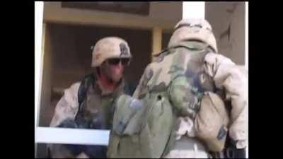 Marines find an insurgent hiding inside of a large building in Fallujah. They break the window and give him a grenade as a gift. Afterwards they make entry into the building and finish clearing it.