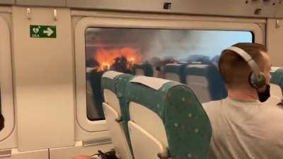 Train surrounded by wildfires during heatwave in western Spain.