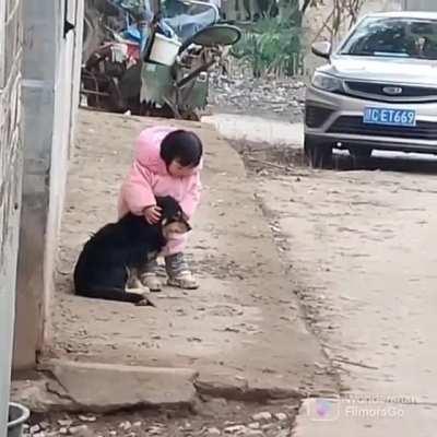 Girl shields her dog from the noise of the fireworks