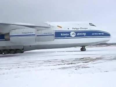 Antonov overshot runway and got stuck in the mud. Emergency services dispatched but the Pilot decided to get it out on his own and almost killed a man.