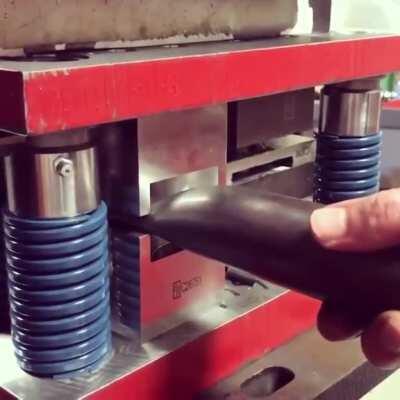 Flattening a metal pipe.