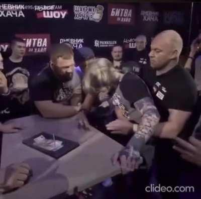 Watch the guy on the right win a prize after challenging the slap champ who's twice his size