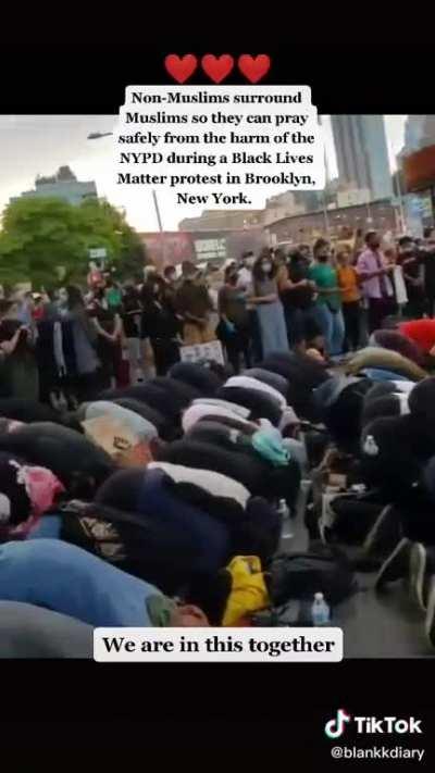 New York muslims praying while protected by protestors