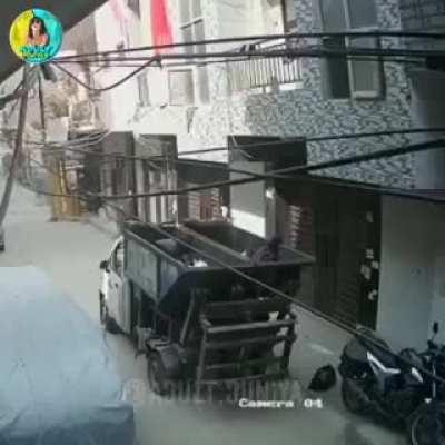 lazy man trying to throw garbage in garbage truck from gallery himself falls in the garbage truck.