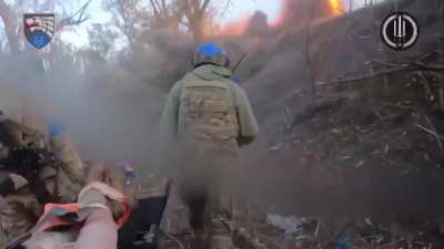 Ukrainians evacuating a wounded comrade under Russian artillery fire