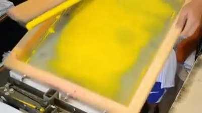 Screenprinting a color image onto a t-shirt.