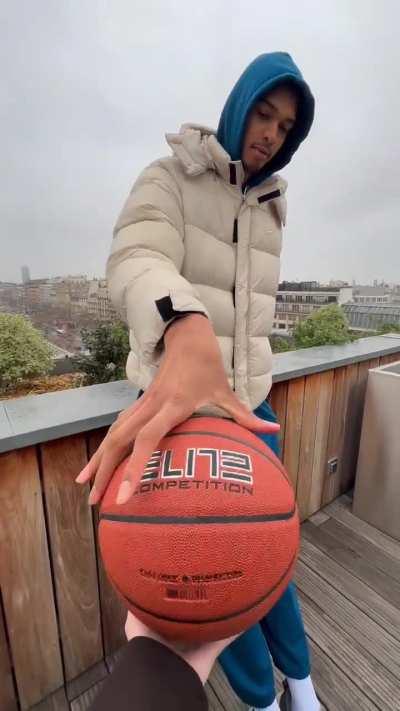 7ft4 Victor Wembenyama palms a basketball with 2 fingers.