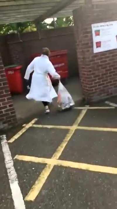 Dragging a trash bag across asphalt and throwing it