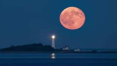 Rare Blood-Red Full Moon Rise Above Boston Light. [babaktafreshi]