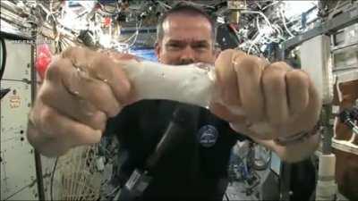 Wringing out water from a towel in space