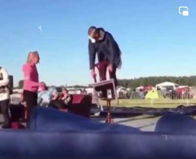 Standing on a table and hitting the table with a chair