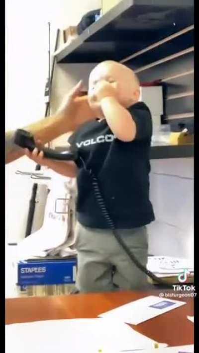 Little businessman imitates his father on the phone