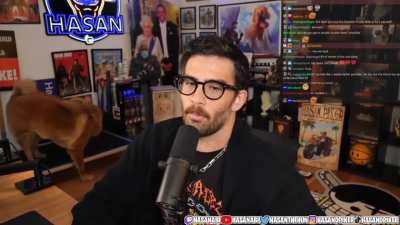 Hasan reaching for something and seemingly shocking his dog to keep her in camera view