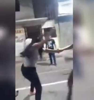 Stray dog pulls down woman's pants as she brawls with another in the street