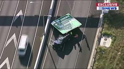 Highway sign falls on a moving car