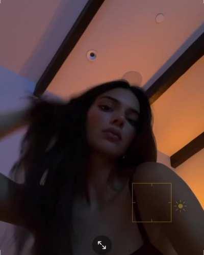 Brushing her hair back