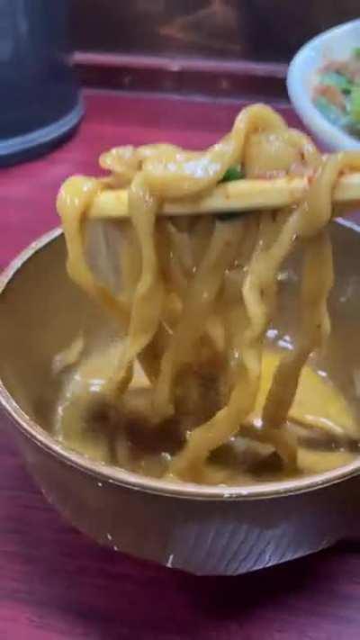 Dipping thick ramen noodles into raw egg and gyofun fish powder at Suzuki (Tokyo)