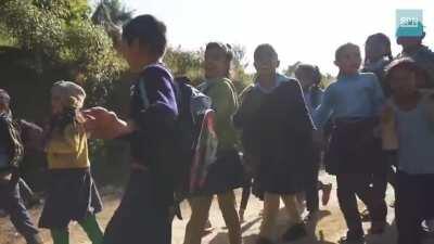 Nepalese kids singing and dancing on a Nepalese folk song on their way to home from school.