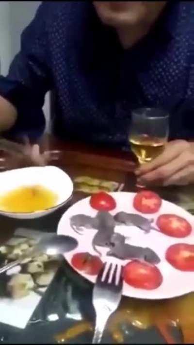 Chinese man eating some mouses