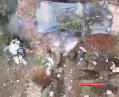 Ukrainian drones drops high explosive munition on Russian soldiers in trench