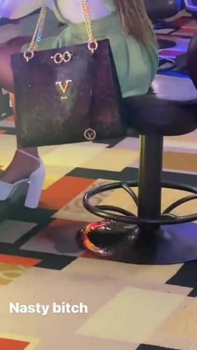 This woman is urinating while sitting at the arcade machine.