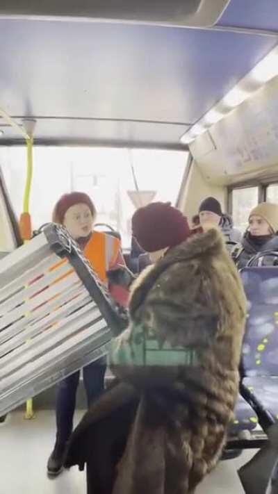 a woman in Russia tries to carry the bench into the bus